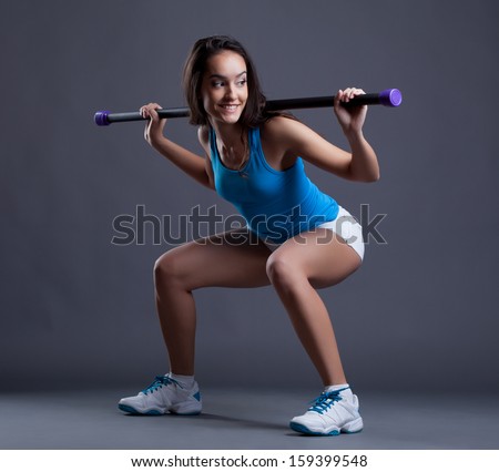 Smiling Sporty Woman Crouches With Fitbar