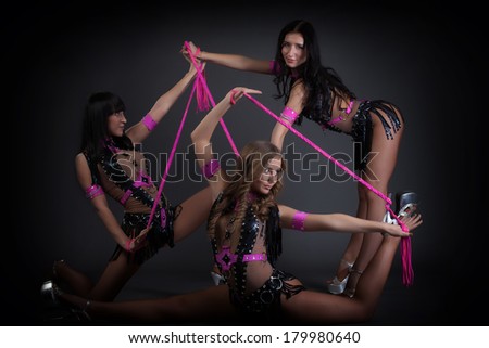 Young dancers posing in erotic costumes with ropes