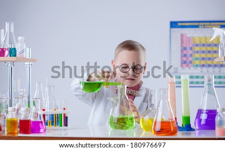 Funny young chemist pouring reagent into flask
