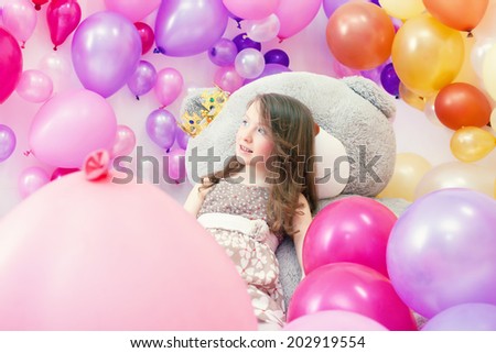 Smiling little lady posing lying on big teddy bear