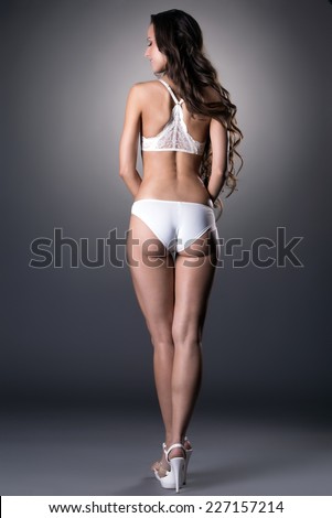 Rear view of underwear model posing on gray backdrop