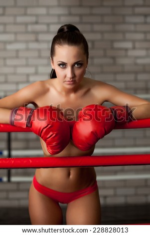 Attractive brunette posing topless in boxing ring