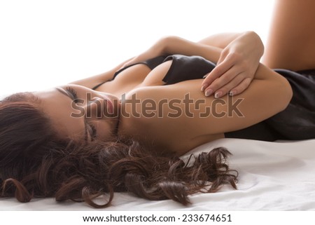 Close-up of seductive woman lying hugging herself