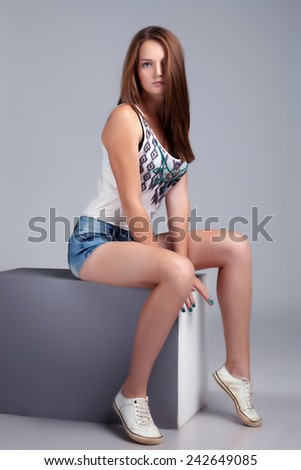 Athletic young model sitting on cube