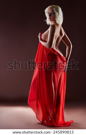 Curvy blonde posing naked with red silk cloth