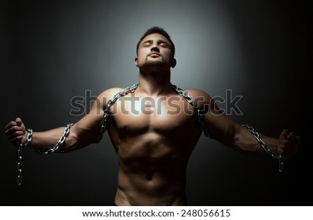 Concept of liberation. Naked man breaks chain