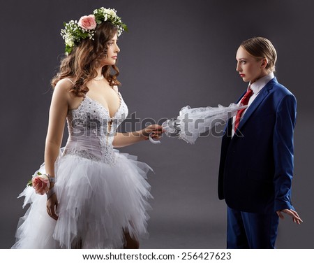 Gay marriage. Sexy bride pokes groom with umbrella