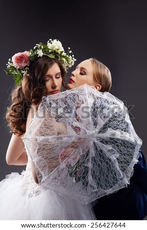 Homosexual girlfriends posing in wedding costumes