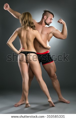 Strong guys attract sexy girls. Studio photo