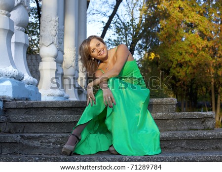 Beauty woman in green clothes sit on stair