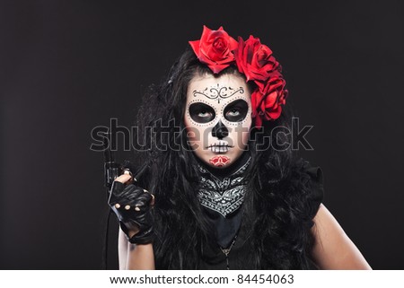 Serious woman in day of the dead mask with gun
