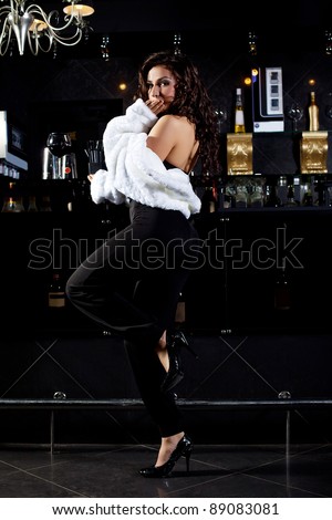 Sexy girl in retro fur coat stand near bar