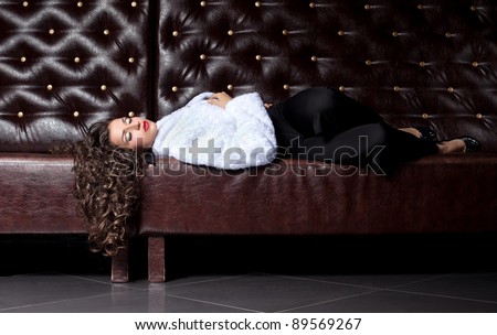 Beauty woman lay on leather sofa