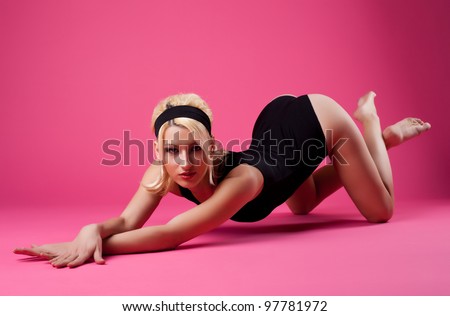 cute woman sexy posing in black sport suit on pink