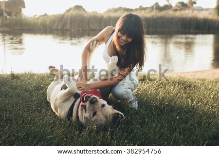 Girl playing with dog on grass