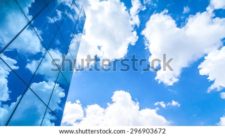 clouds reflected in the many mirrored facets of a modern office building