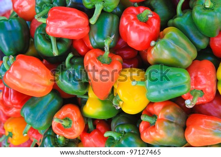 Red, green and yellow sweet  peppers natural background.