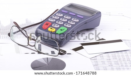 Business still-life of tables, payment terminal, credit Cards, eyeglasses