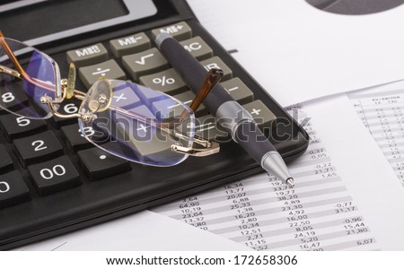 Business still-life of a ink pen, charts, eyeglasses, calculator