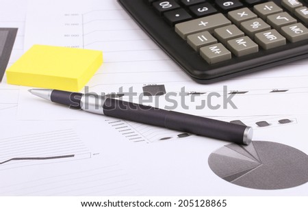 Business still-life of a blue pen, yellow stickers, graph, calculator