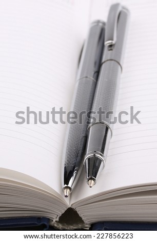Business still-life diary, two shiny pen; focus on pen tip
