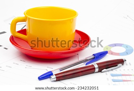 Business still life of pens, cup, saucer