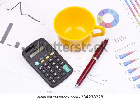 Business still life of pen, cup, saucer, calculator