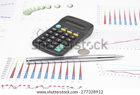 Business still-life of a ink pen, coin, charts, calculator