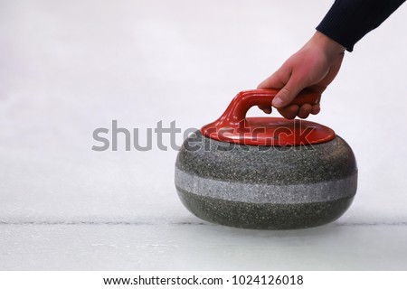 Hand holding curling stone