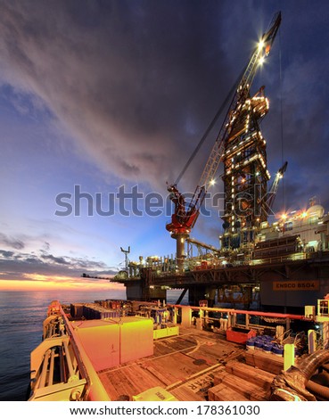 PALAWAN, PHILIPPINES -Â?Â? MAY 07, 2013: Photo of a semi-submersible drilling rig during cargo operation with a platform supply vessel at sunset in Palawan, Philippines in 2013.