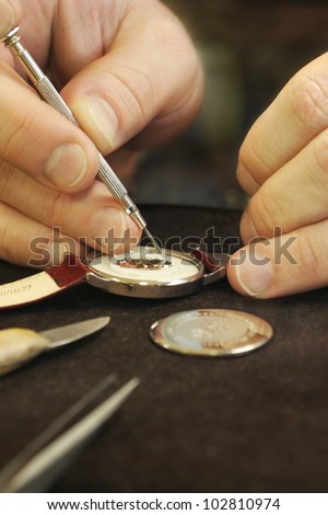 Close Up of watchmaker repairing battery in watches