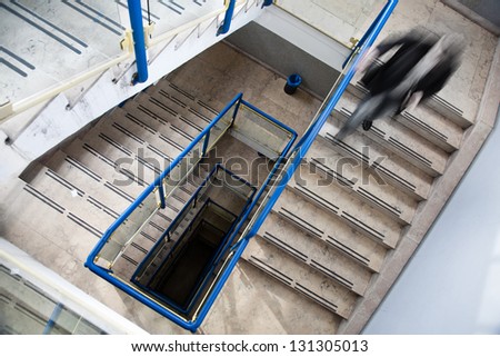 Businessman walking down the stairs. Motion blur visualizies the speed and dynamics.