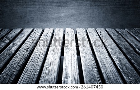 Grunge aged sunny monocromatic color wooden lake pier with small waves on the lake background.