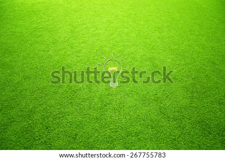 Hand drawing creative light bulb on sunny green soccer field grass or nature field background as concept.