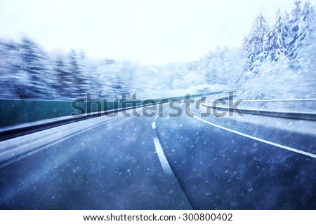 Dangerous blurred highway winter driving. Winter snowy conditions on the highway. Motion blur visualizies the speed and dynamics.