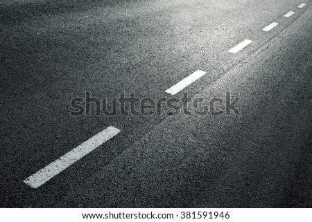 White dotted line on city asphalt road background.