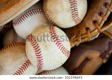 closeup of baseballs and leather glove used for baseball practice
