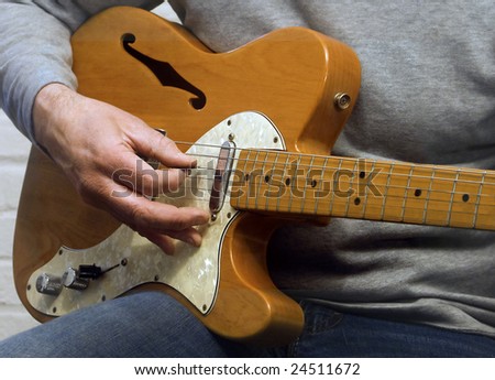 Close-up of hand playing electric guitar