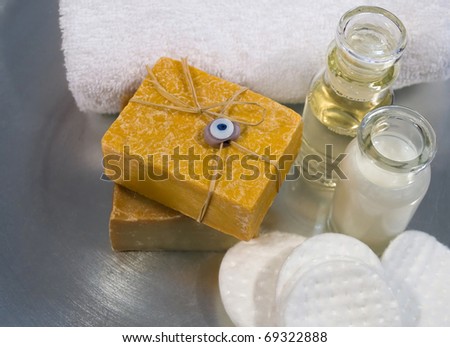 Spa and skincare products arranged on a silver tray, including handmade soaps, cleansers and essential oils