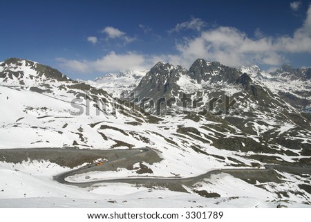 A road runs through a mountain landscape in winter time