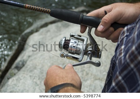 A fisherman lets his lure sink a little before reeling it in, in an attempt to catch a fish with his spin reel.