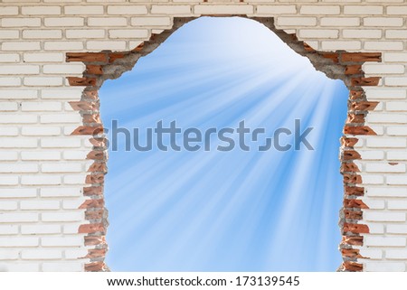blue sky with sunlight through the hole in the brick wall