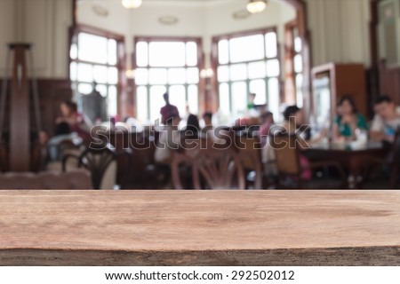 Empty wood table and blurred coffee shop  background.
