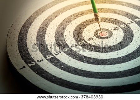 dart arrow hitting in the target center of dartboard,abstract of success