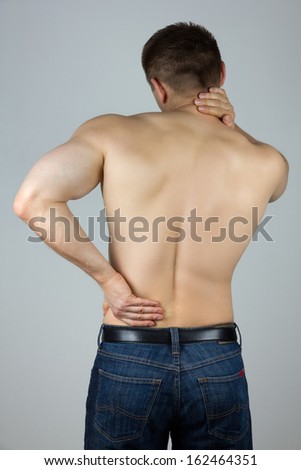 Young man with back and neck pain in the red zone