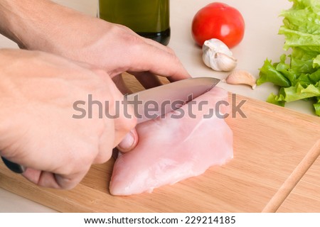 Food preparation. Man\'s hands cutting chicken