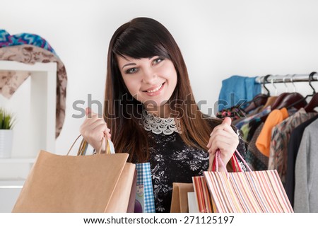 Young beautiful smiling woman holding paper bags with purchases. Sale and shopping concept