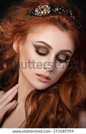 Portrait of beautiful sensual red-haired woman with black hair accessory looking down and touching her neck