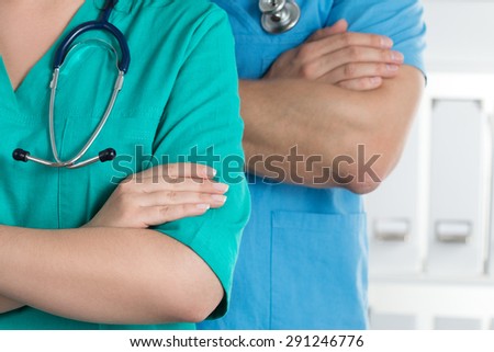 Two doctors standing with their arms crossed on chest ready to work. Healthcare and medical concept.
