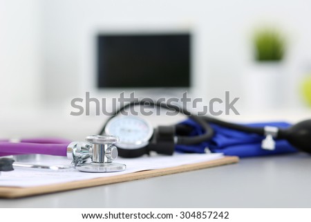 Medicine doctor\'s working place. Stethoscope and manometer lying on table at physician\'s office. Healthcare, health life and medical concept